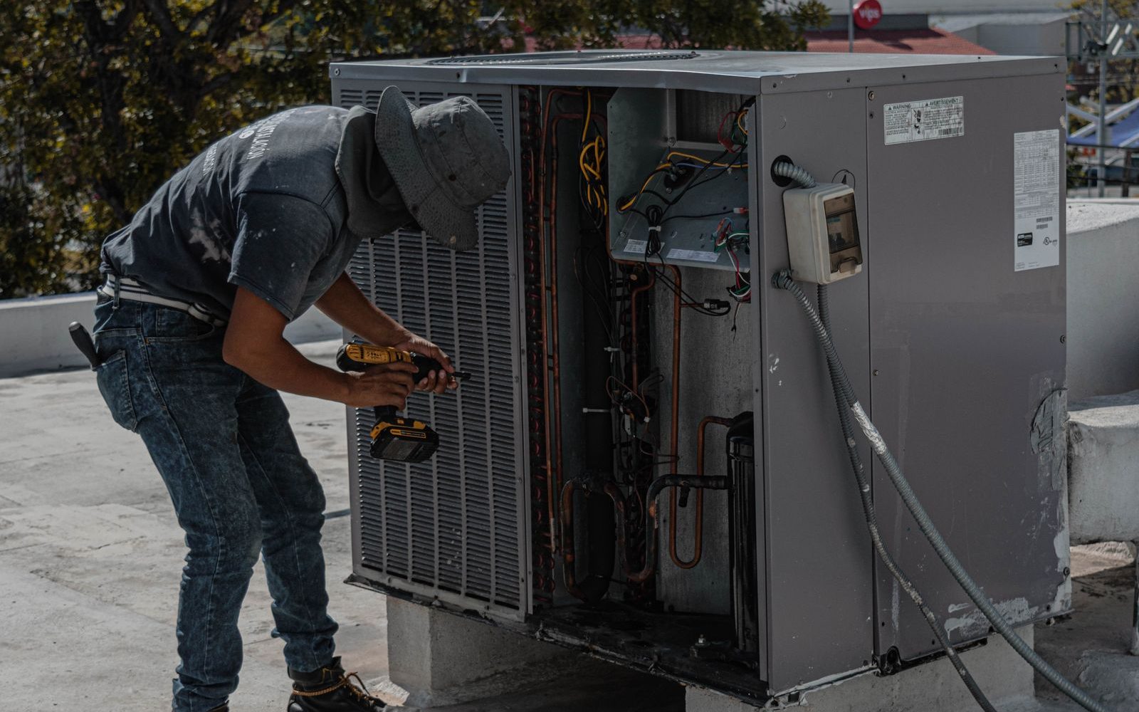 Technician servicing an outdoor air conditioning unit